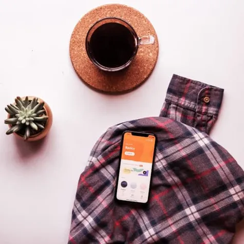 Coffee cup and phone on a tartan blanket